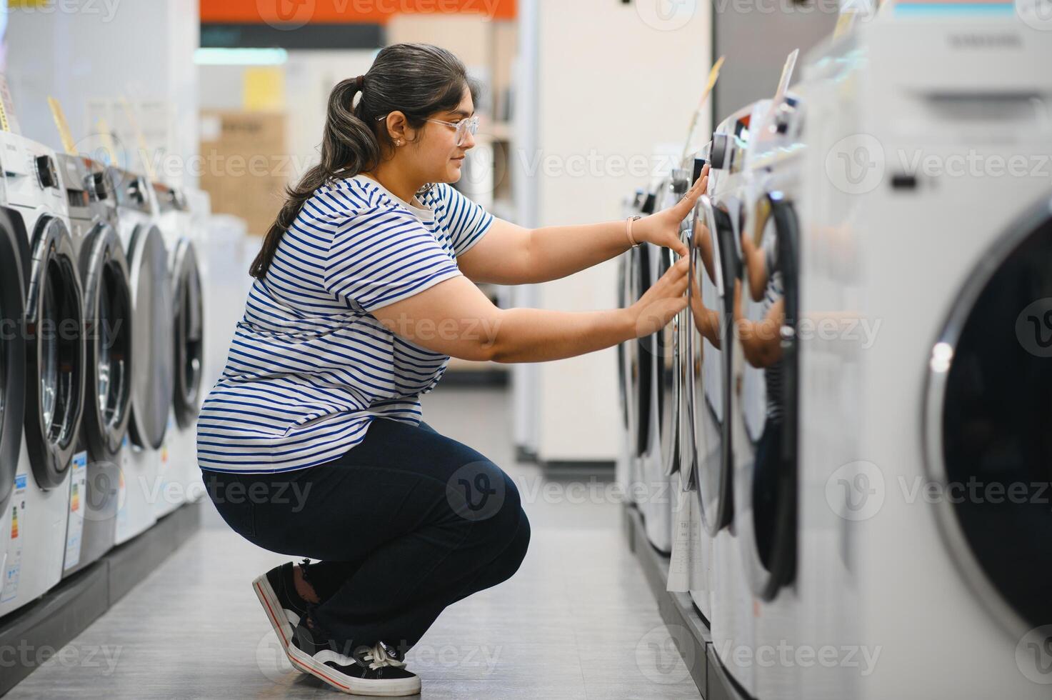 Indian woman chooses a refrigerator in a home appliance store photo