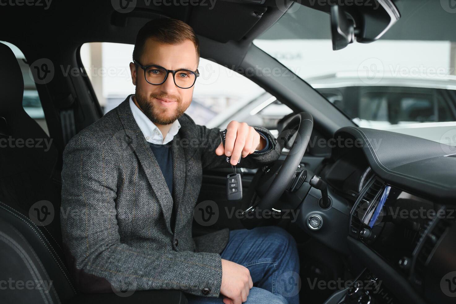 Handsome businessman driving car before buying photo