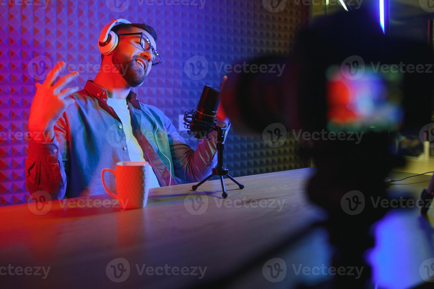 A blogger records content in his studio. The host of the blog is a young man who is very enthusiastic about telling his subscribers a story. photo