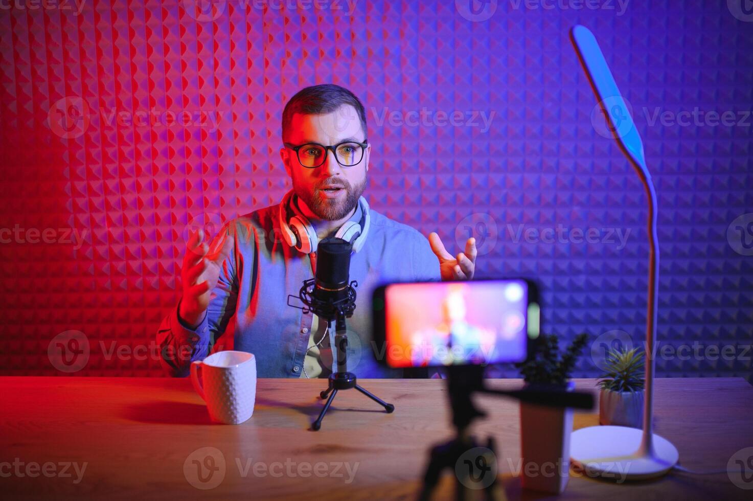 A blogger records content in his studio. The host of the blog is a young man who is very enthusiastic about telling his subscribers a story. photo