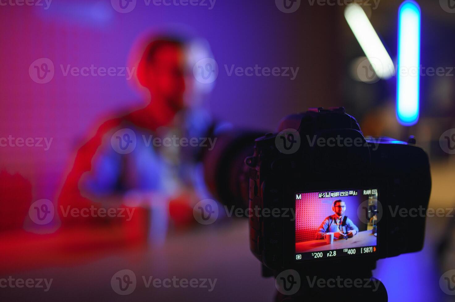A blogger records content in his studio. The backstage photo was taken from behind one of the participants in the shooting, at the beginning of the shooting when the blogger is preparing.