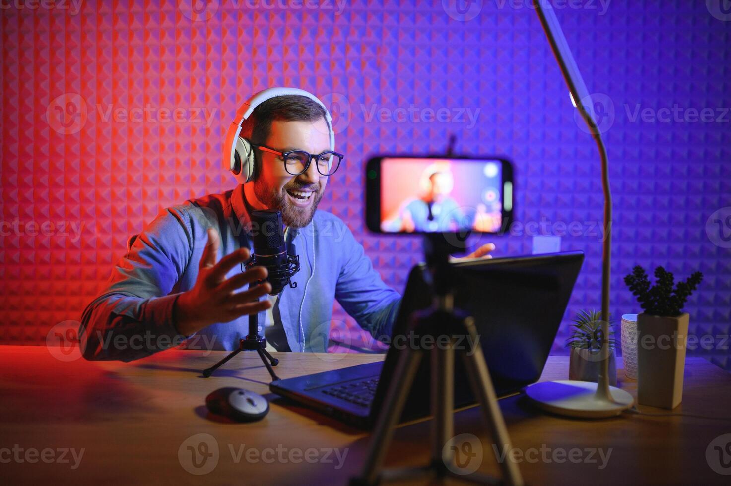 A blogger records content in his studio. The host of the blog is a young man who is very enthusiastic about telling his subscribers a story. photo
