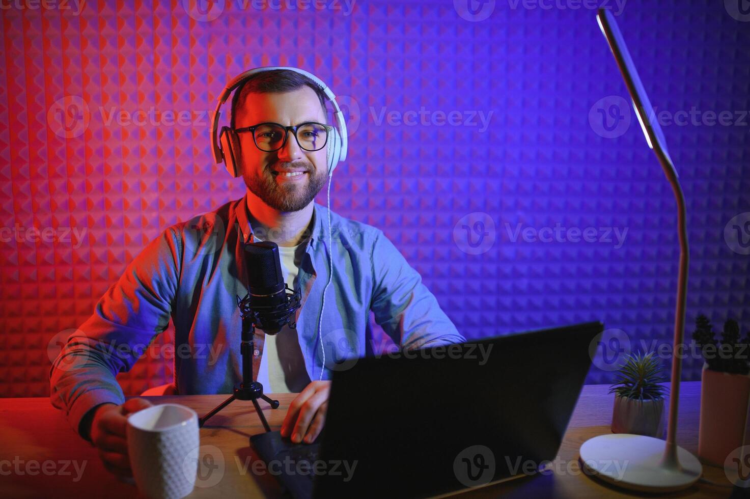vlogger using smartphone to film podcast in studio. blogger with mobile phone, microphone and headphones filming for social media broadcasting career. photo