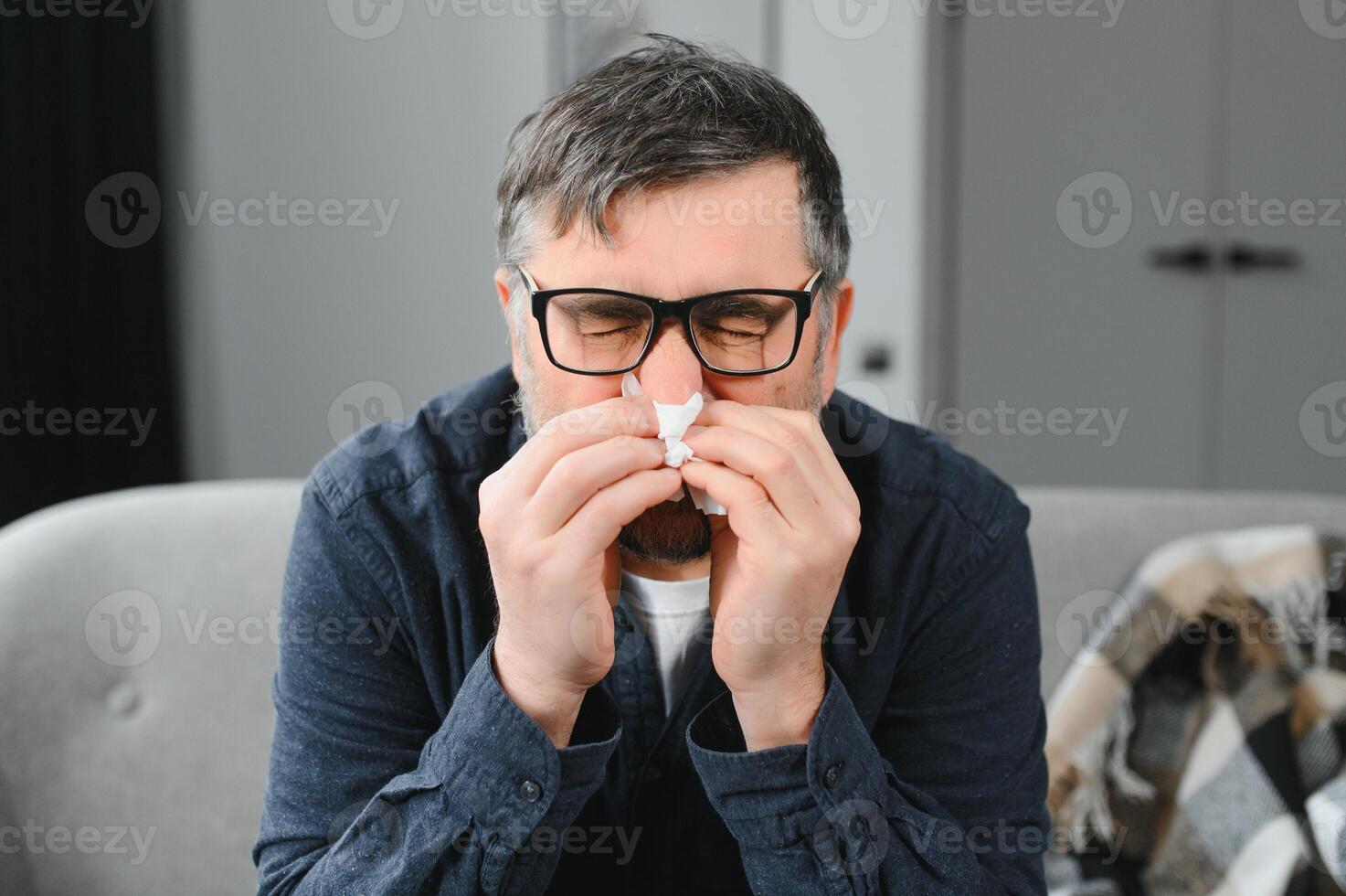 old man get a cold and sneeze with tissue paper at home photo
