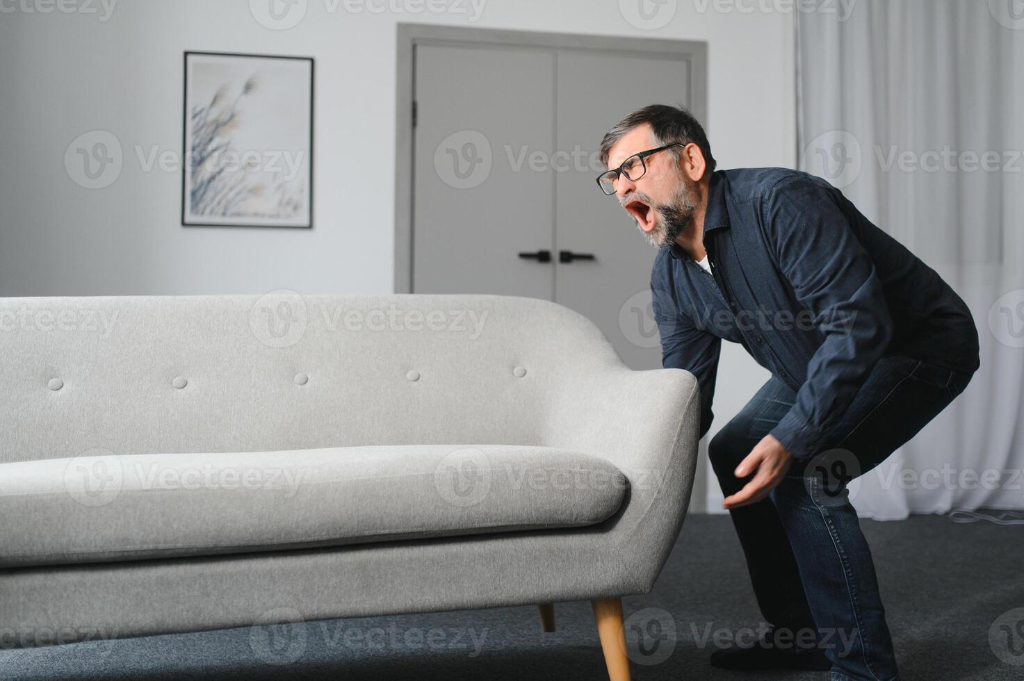 Senior man is suffering from pain in lower back at home photo