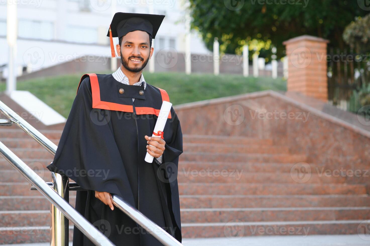 Handsome indian graduate in graduation glow with diploma. photo