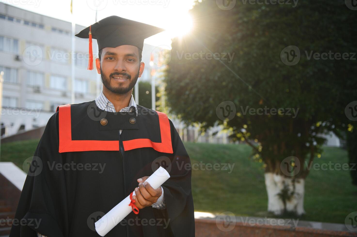 Handsome indian graduate in graduation glow with diploma. photo