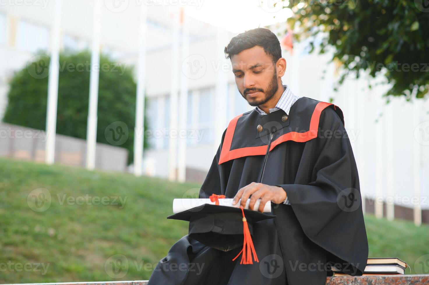 Young indian graduated boy holding his graduation degree convocation ceremony. student graduate posing. photo