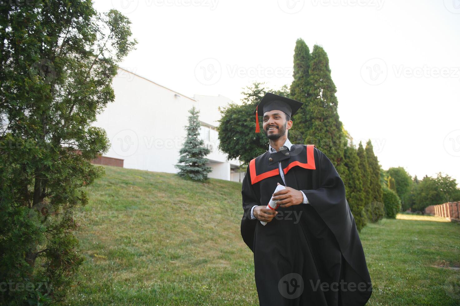 Handsome indian graduate in graduation glow with diploma. photo