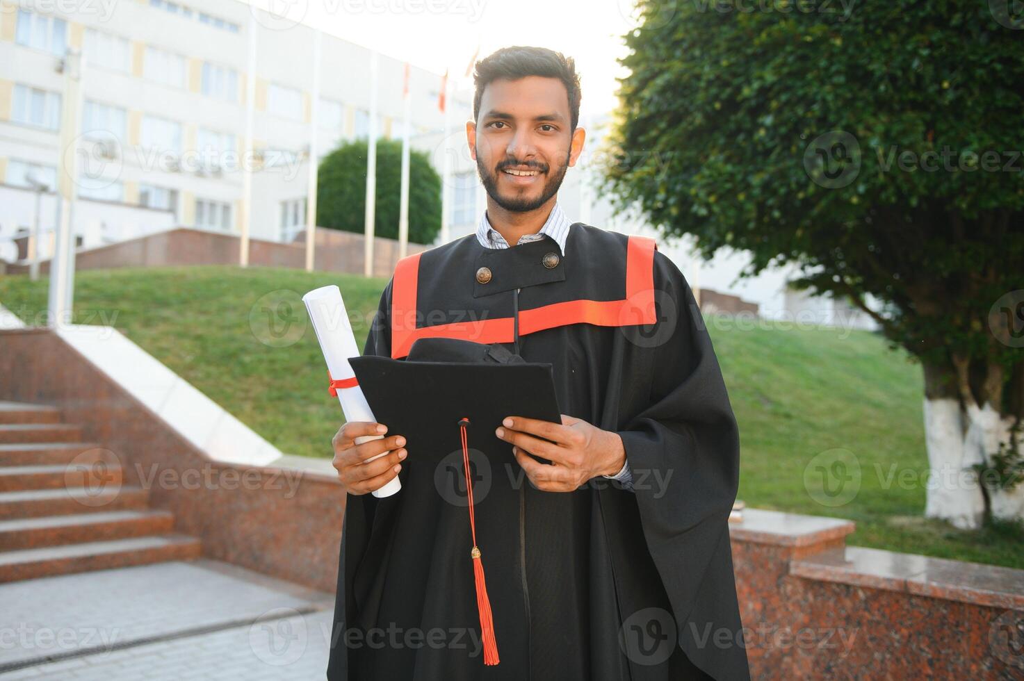 Handsome indian graduate in graduation glow with diploma. photo