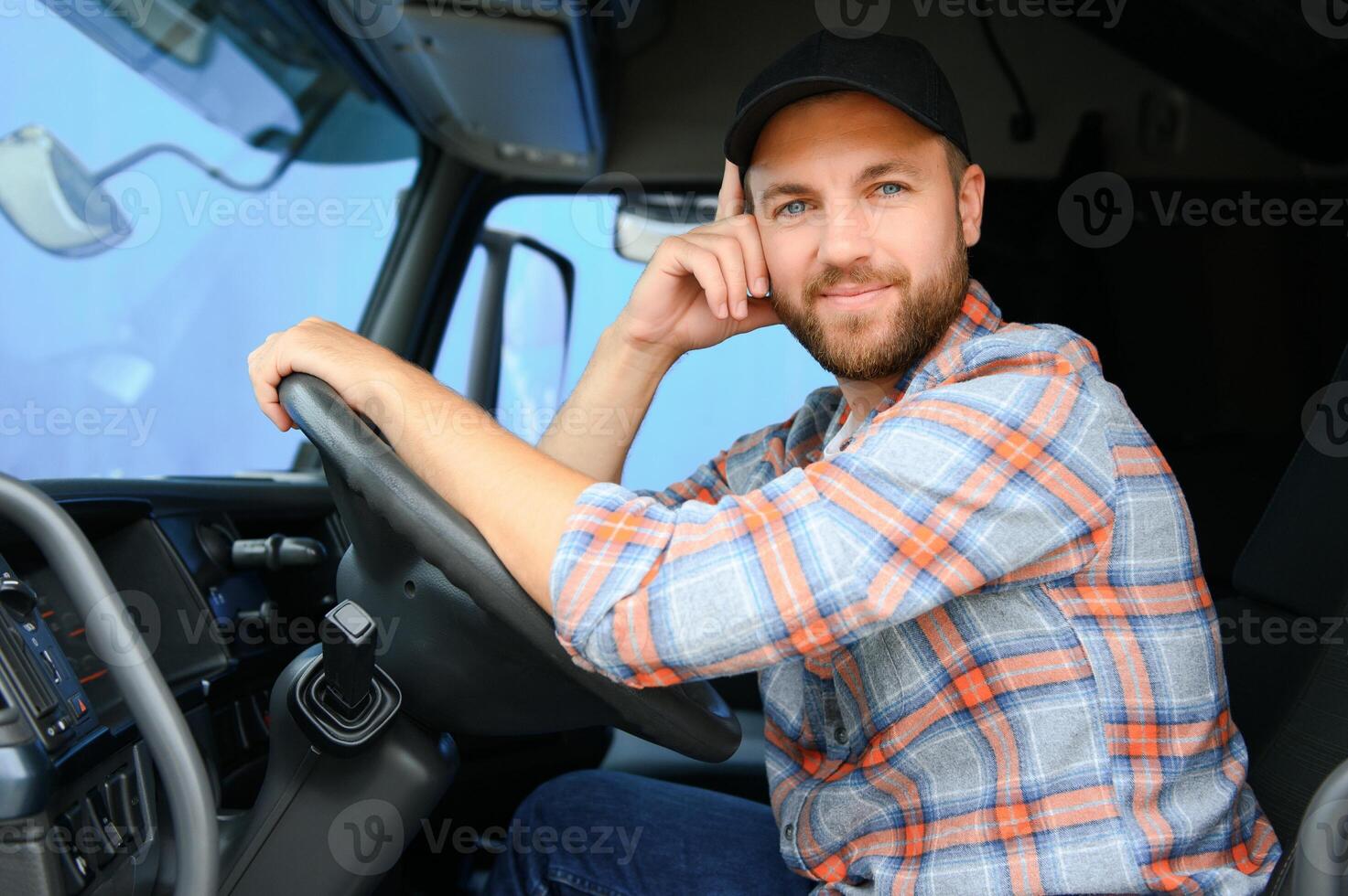 Side view of professional driver behind the wheel in truck's cabin. photo