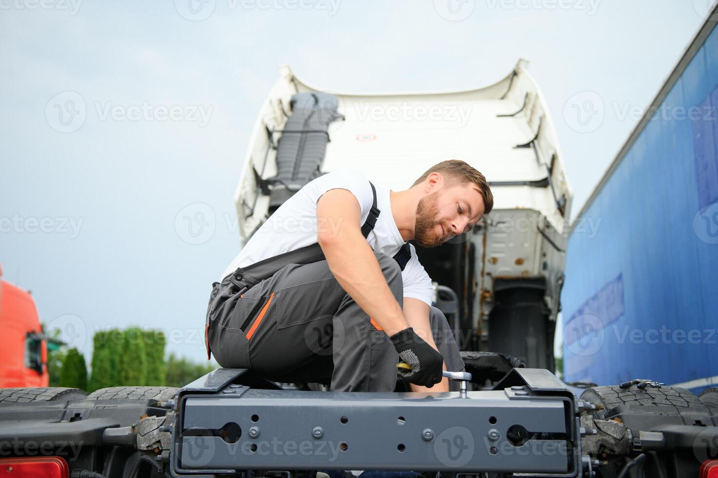 Semi Truck Under Maintenance. Caucasian Truck Mechanic Working to Fix the Tractor. photo