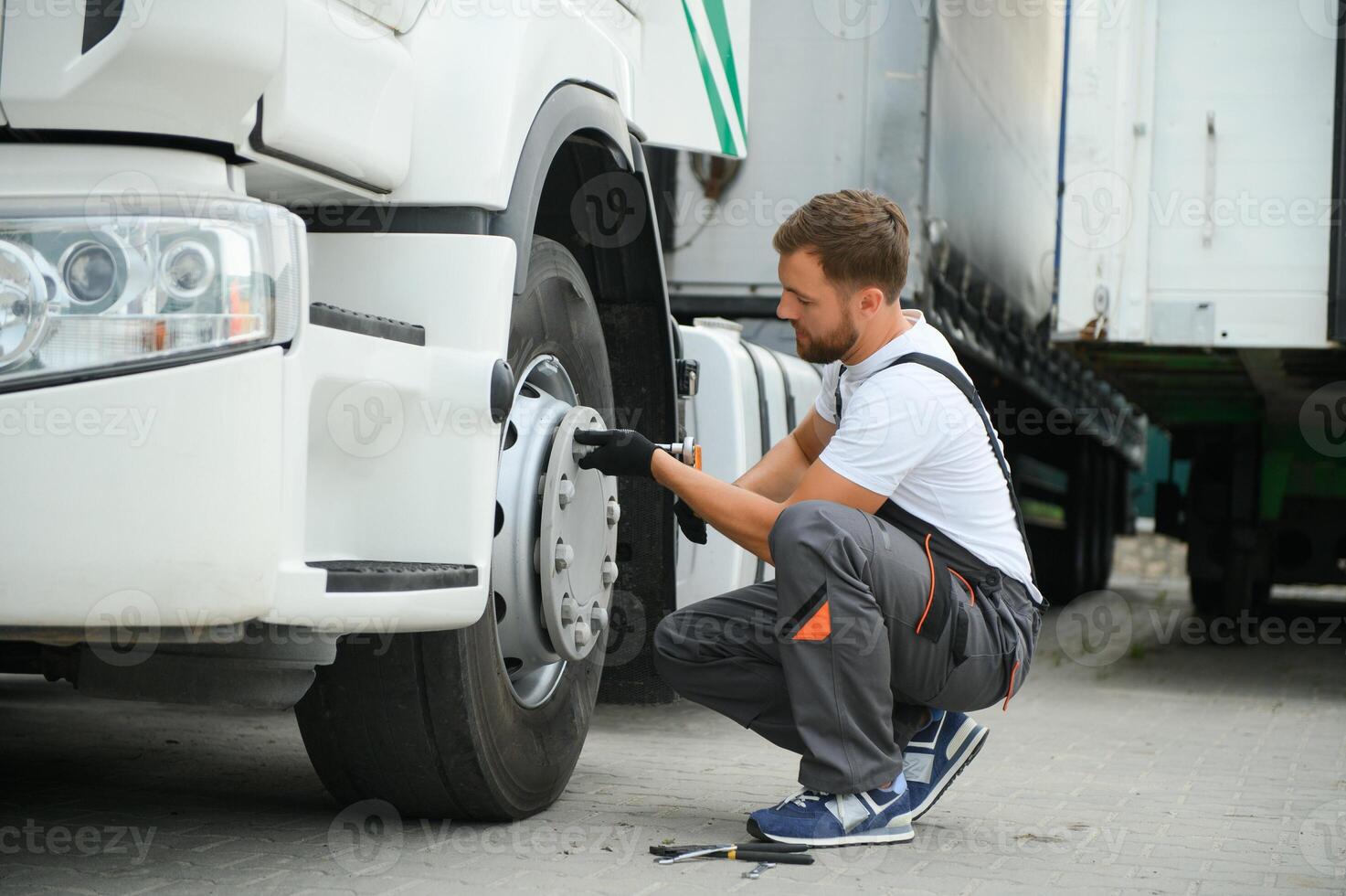 Caucasian Professional Truck Mechanic Rebuilding Heavy Duty Truck Diesel Engine. Automotive Industry Theme. photo