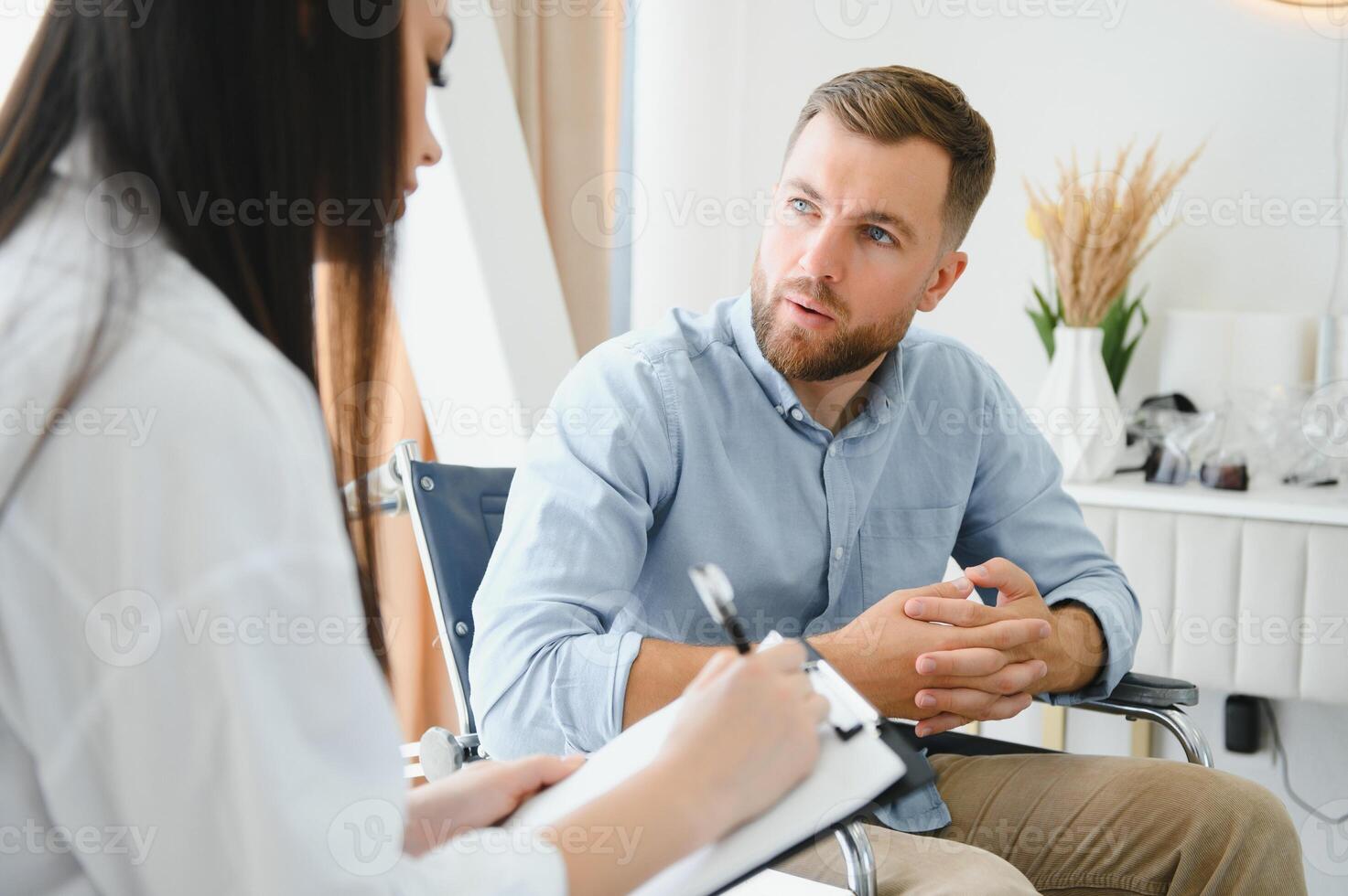 Young bearded man on wheelchair during home psychotherapy photo