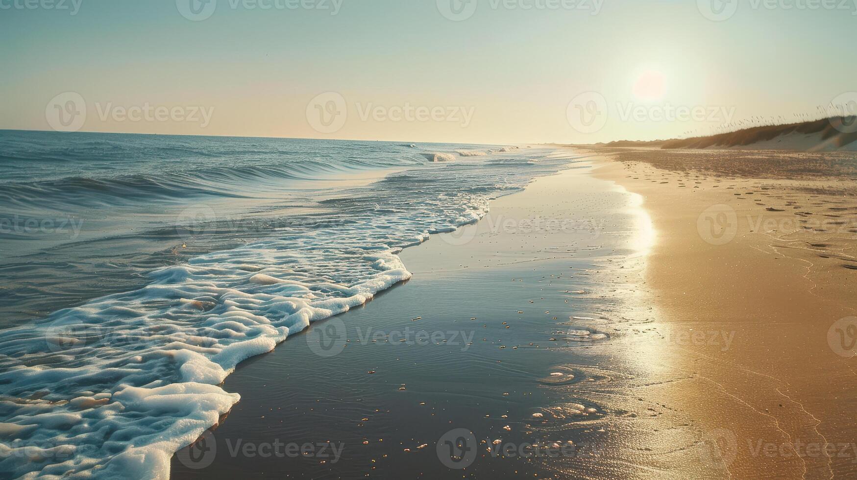 Foamy Waves Crashing on Sandy Beach at Sunset photo