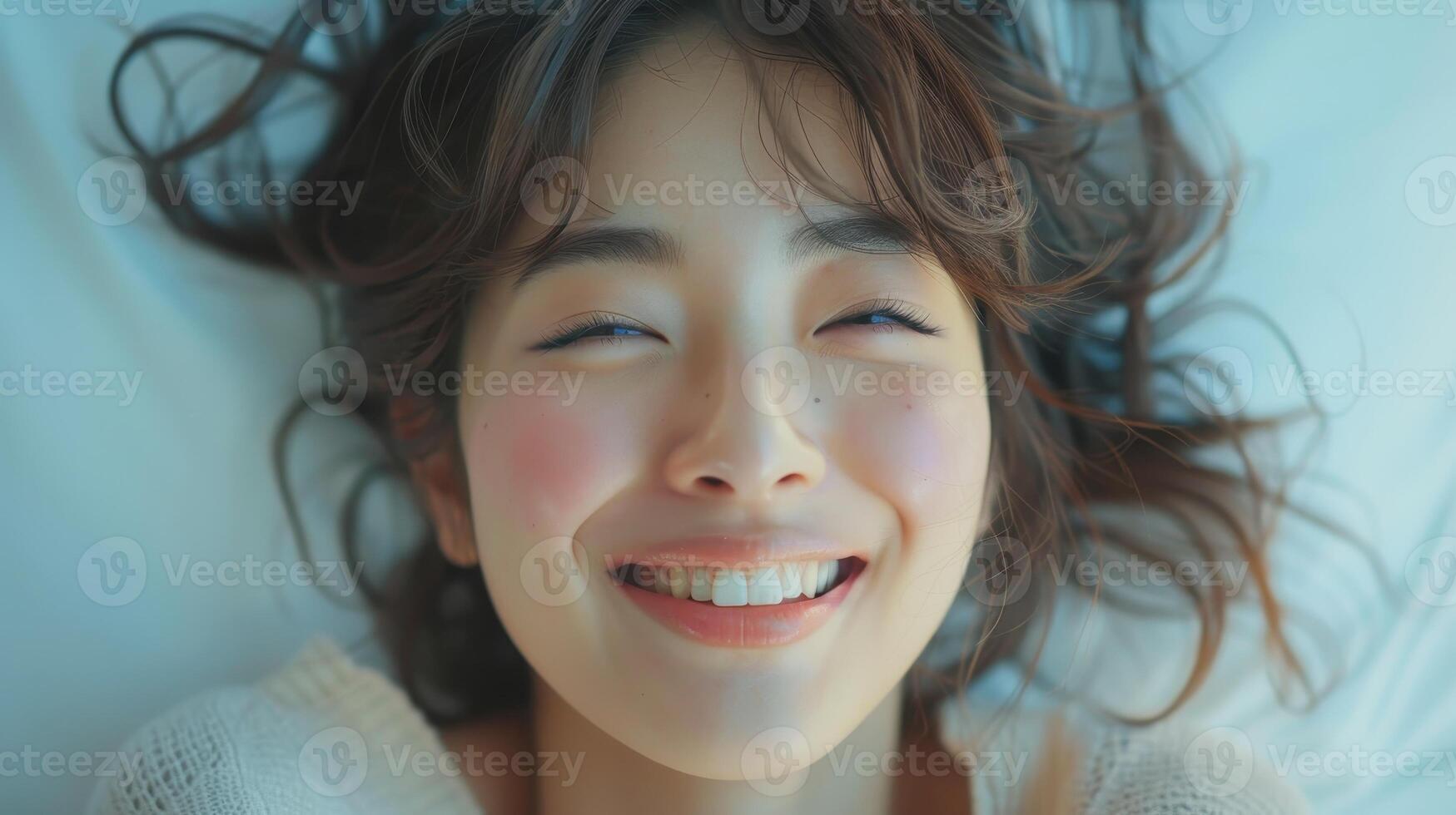 cerca arriba retrato de sonriente mujer con marrón pelo acostado en blanco cama foto