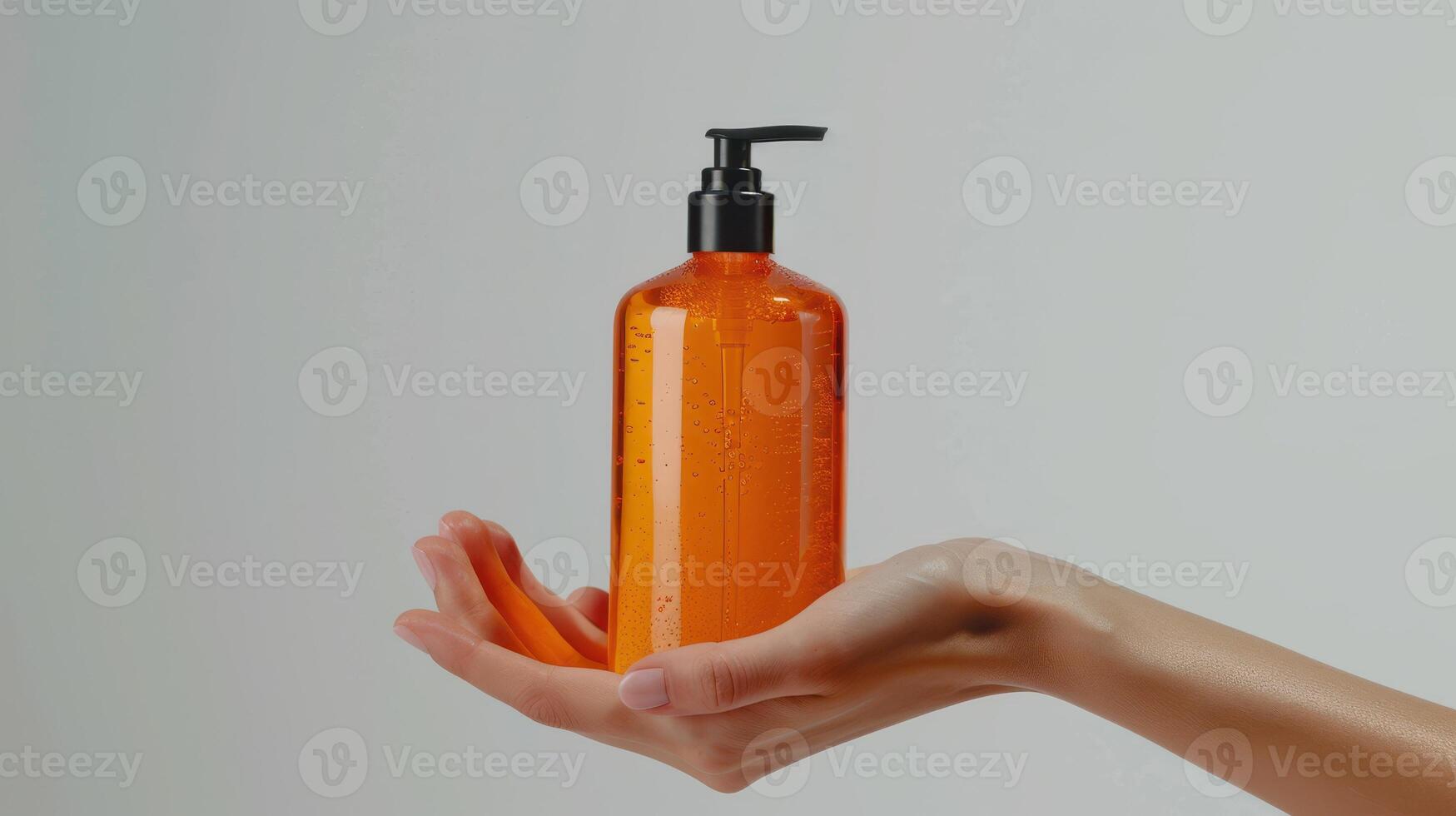 A Hand Holding An Orange Pump Bottle of Liquid Soap photo