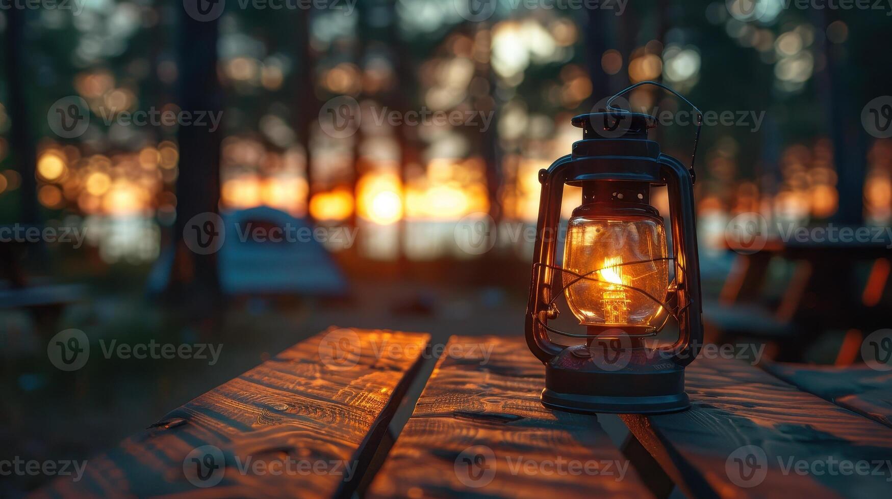 Illuminated Lantern Casting Warm Glow Over Rustic Table at Sunset in Serene Forest Campsite photo