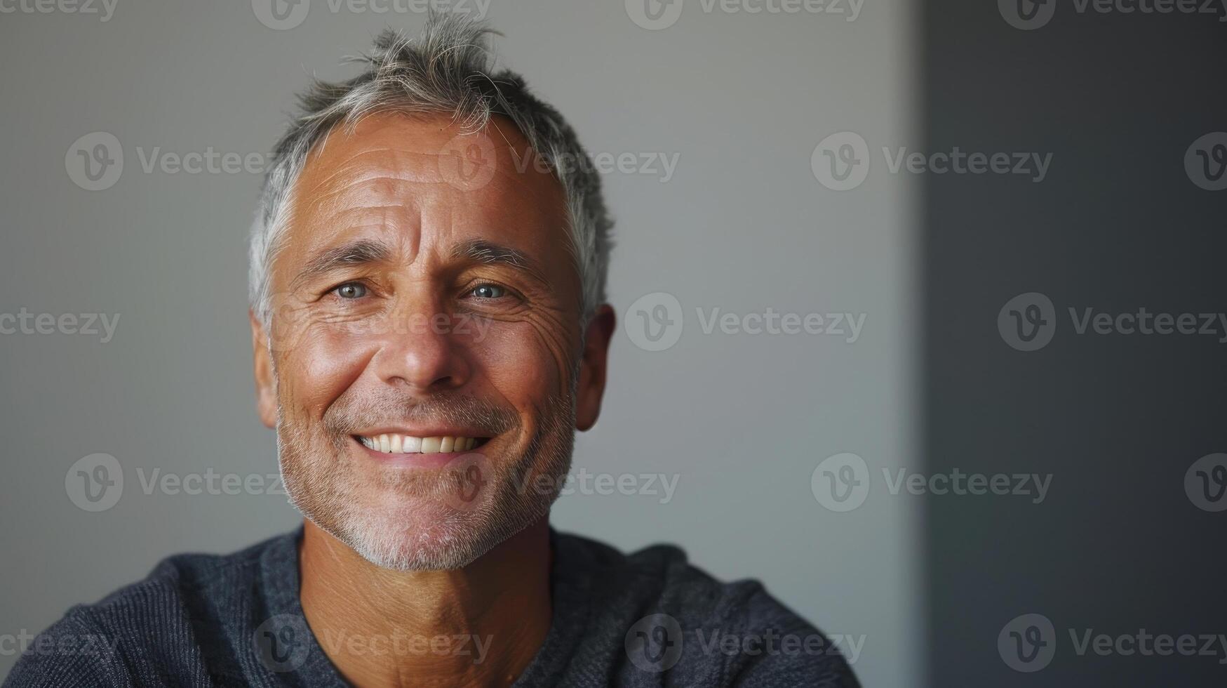 Smiling Older Man With Gray Hair Enjoying a Cozy Indoor Afternoon in a Well-Lit Modern Space photo