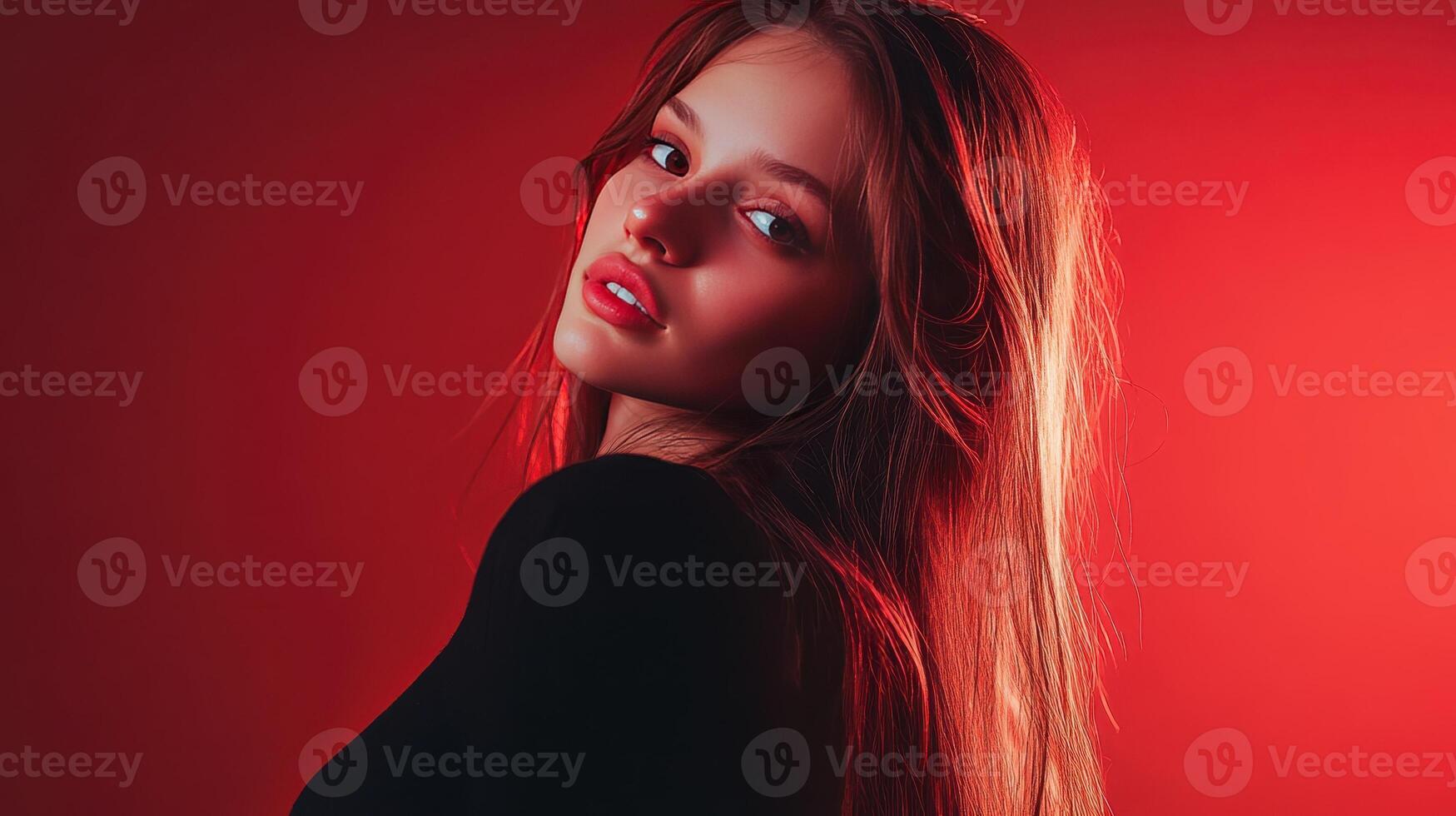 A young woman poses gracefully with flowing hair in a vibrant red setting photo