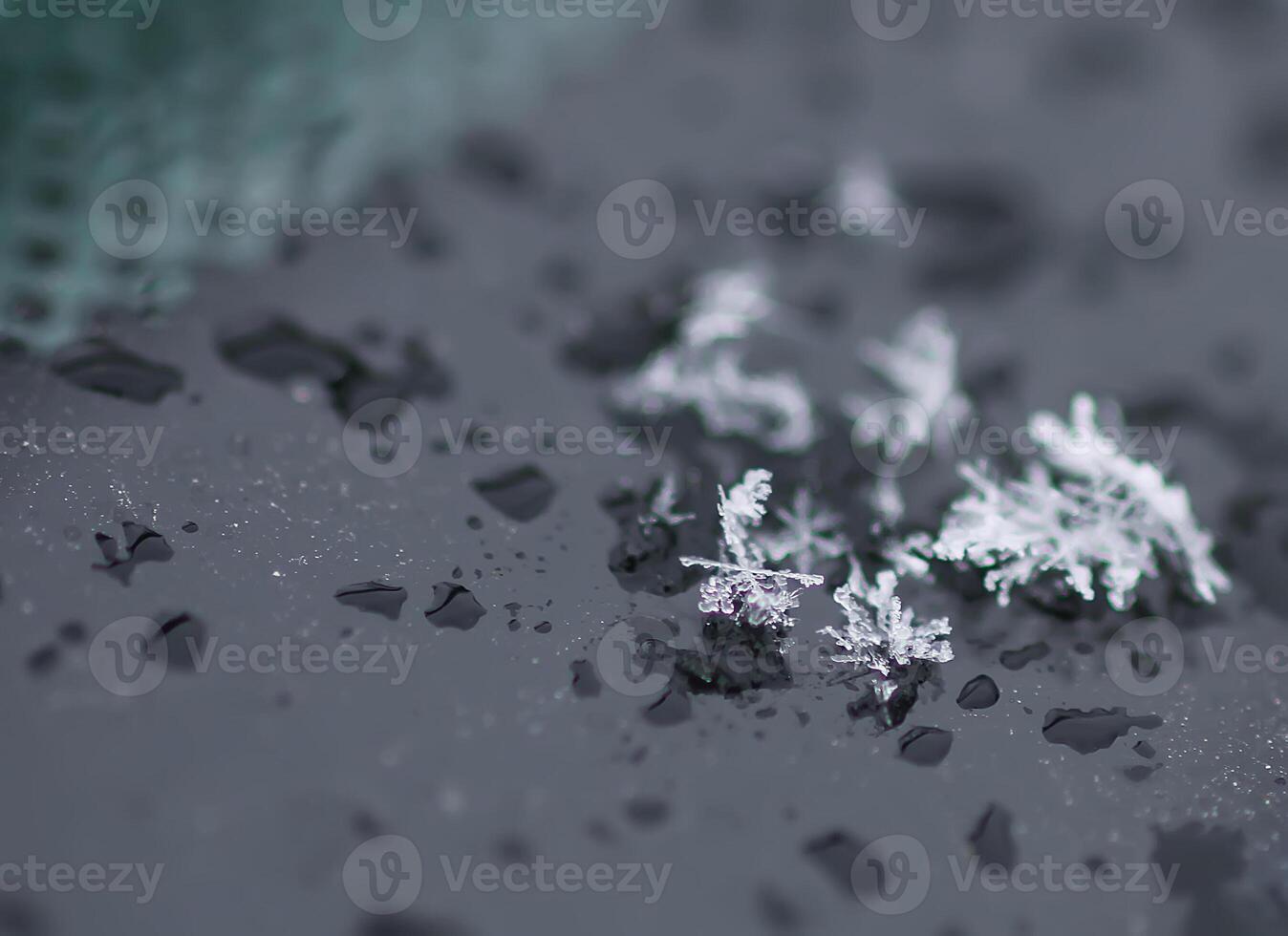Snowflakes during the snowfall on glass surface photo