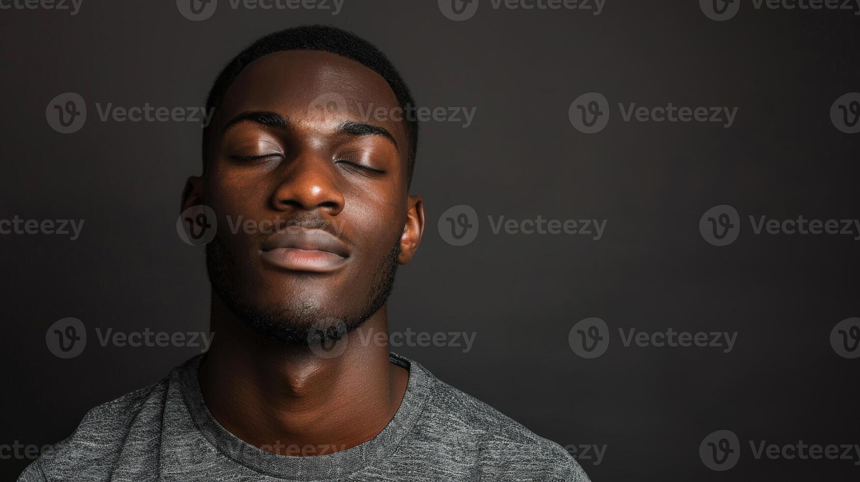 African American Man With Closed Eyes in Solid Background Setting photo