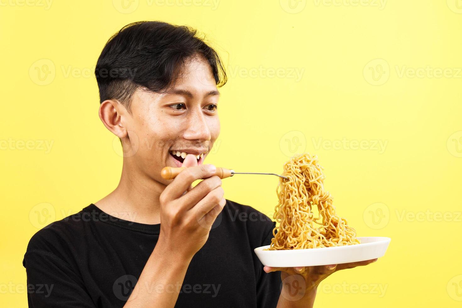 Indonesian Young Man Eating Indomie Fried Noodle photo