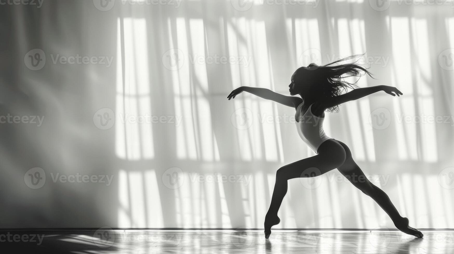 Young female dancer rehearses a dance routine in a well lit studio photo