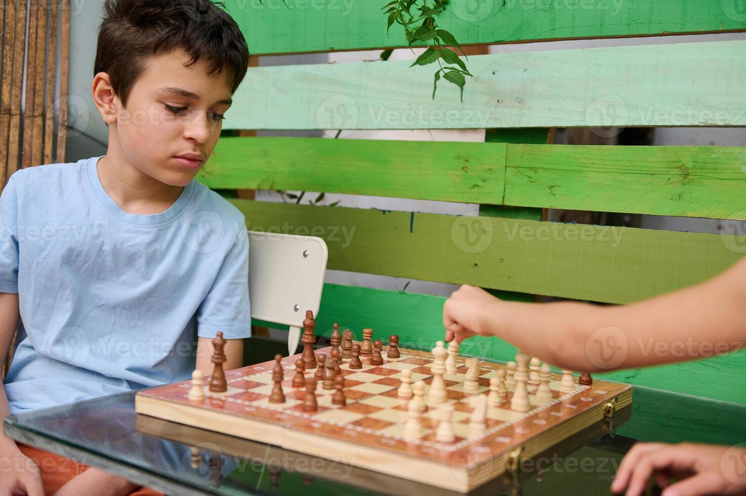 Kids playing a chess game while enjoying time together outdoors photo