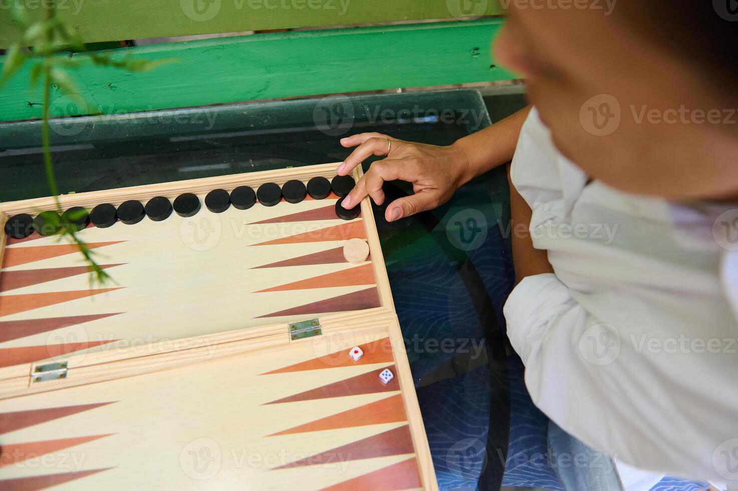 Top view of a person playing a game of Backgammon on a wooden board photo