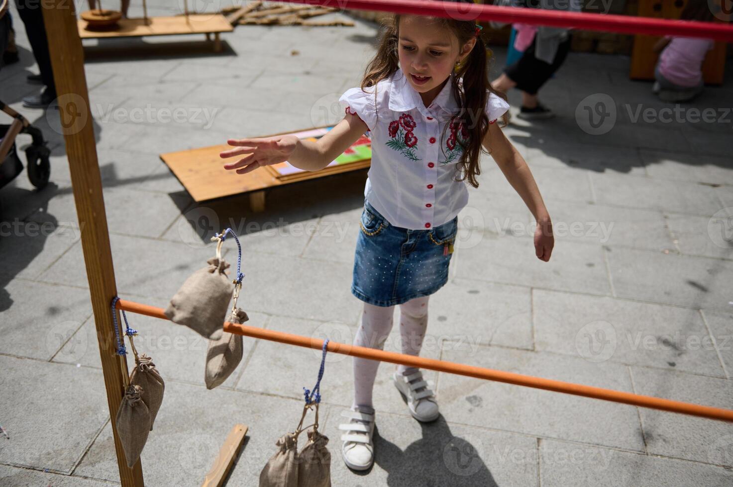 Young girl playing outdoor game at a park event on a sunny day photo