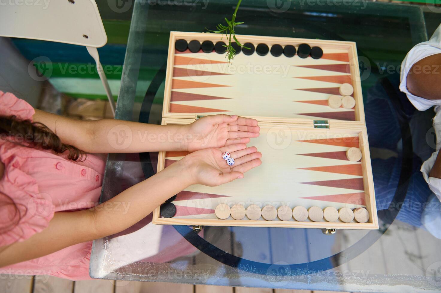 Children playing a game of backgammon together on a glass table photo