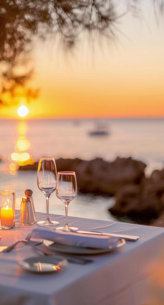 Romantic Sunset Dinner With Wine Glasses by the Ocean photo