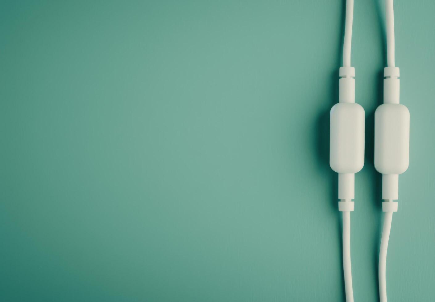 Two White Electrical Plugs on Green Background photo
