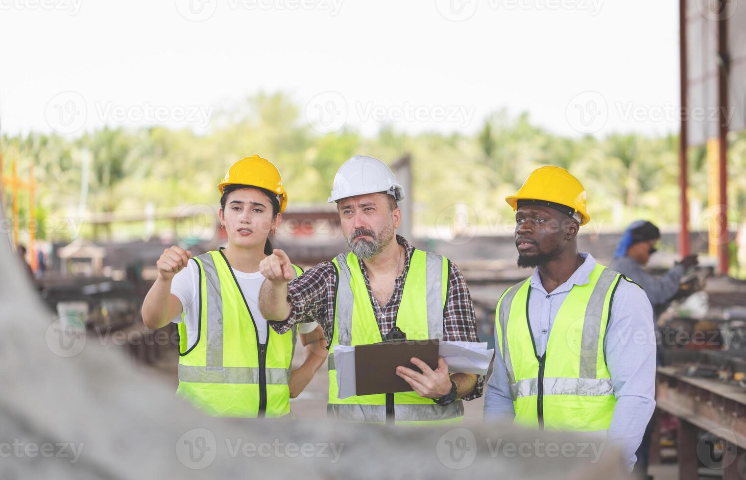 Engineer and foreman worker team with blueprints checking project at construction site photo