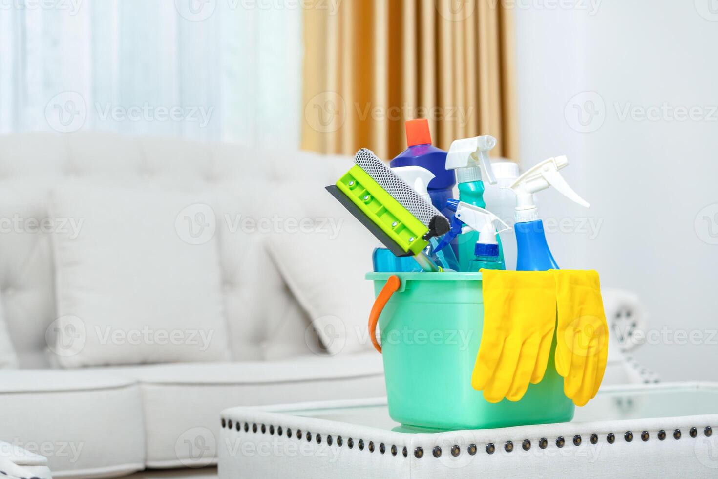 Set of cleaning supplies on the table in room, Bucket with cleaning products, Household equipment photo