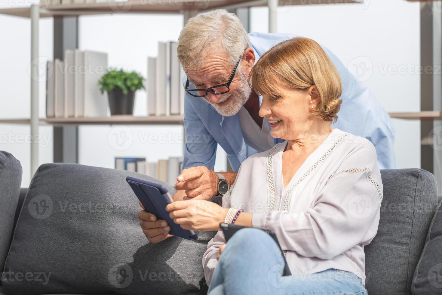 Man and woman using digital tablet read document information at home, Senior couple with digital tablet in living room photo