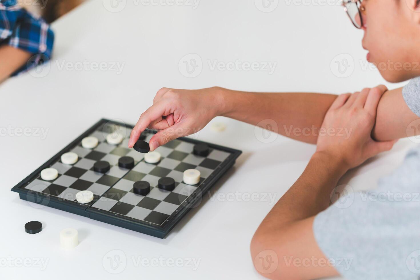 Asian teenage boy and girl playing board game, Asian brother and sister relaxing hobbies playing a game of checkers photo