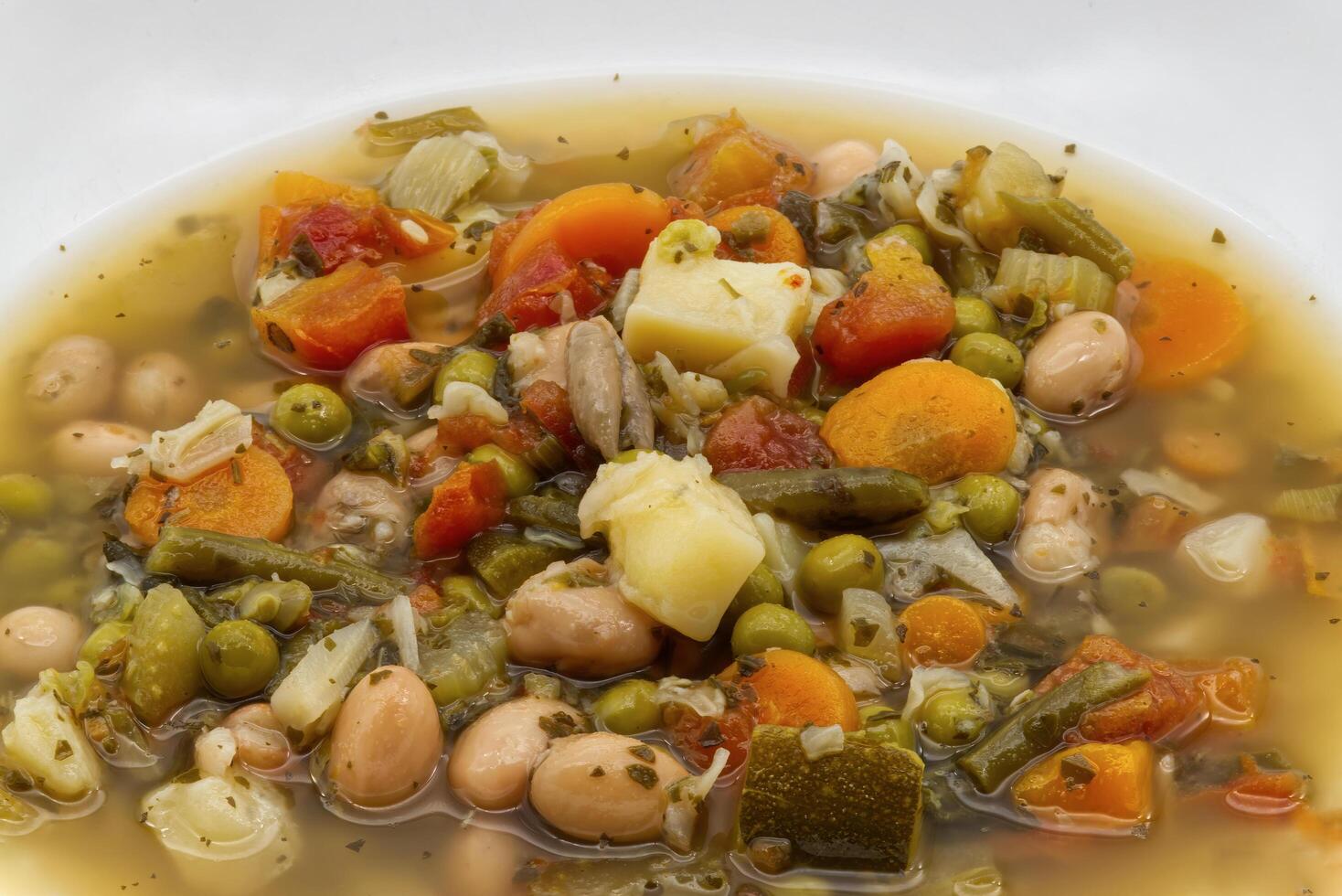 Fresh tuscan soup, zuppa toscana. Italian Minestrone in a white plate. photo