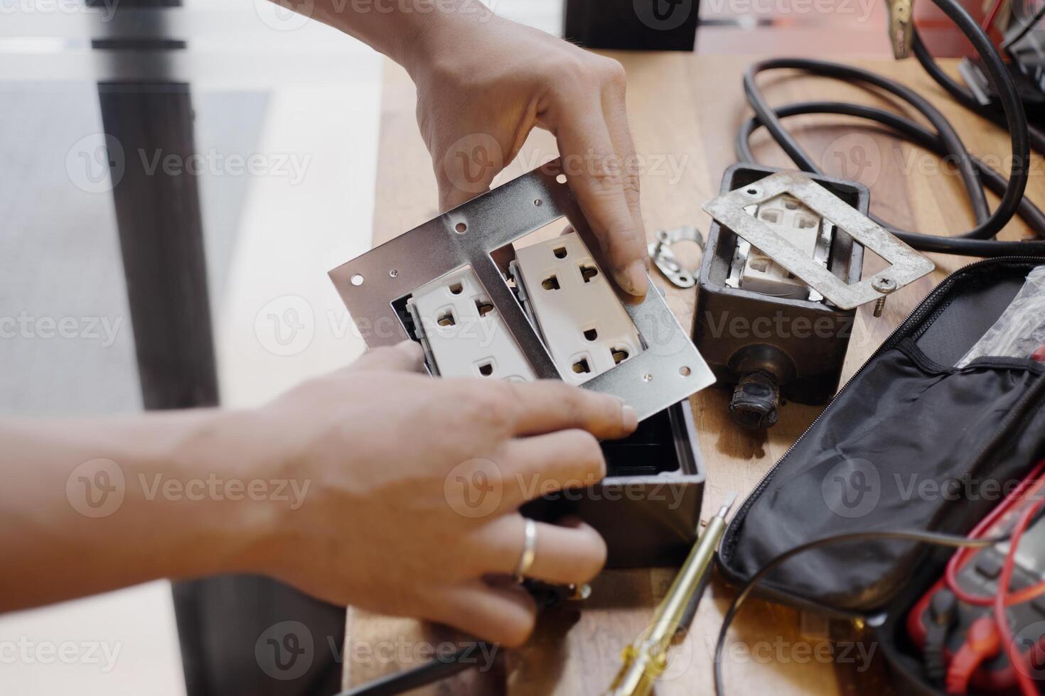 Man Install an Electrical Outlet Receptacle in to rubber box , Attach the Receptacle to the Box photo