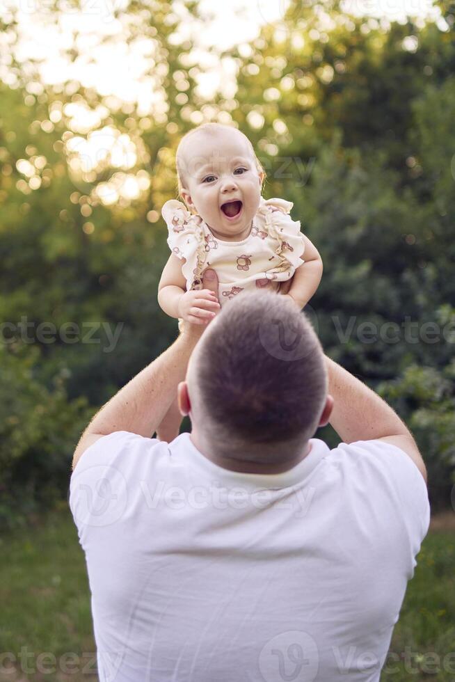 dad playing with his baby daughter in the garden photo