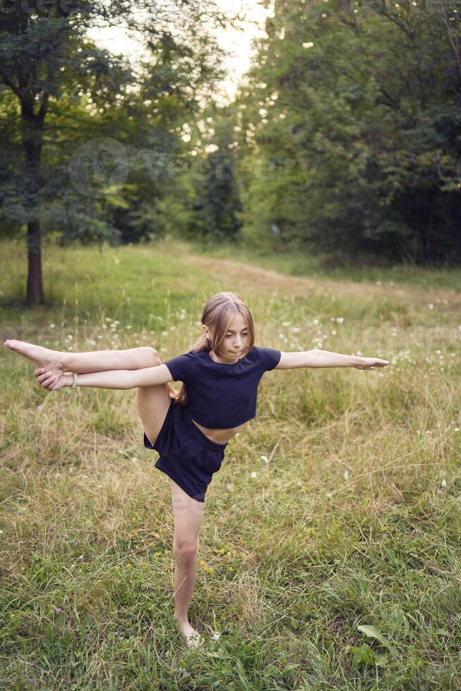 A 10-year-old gymnast practices in the garden photo