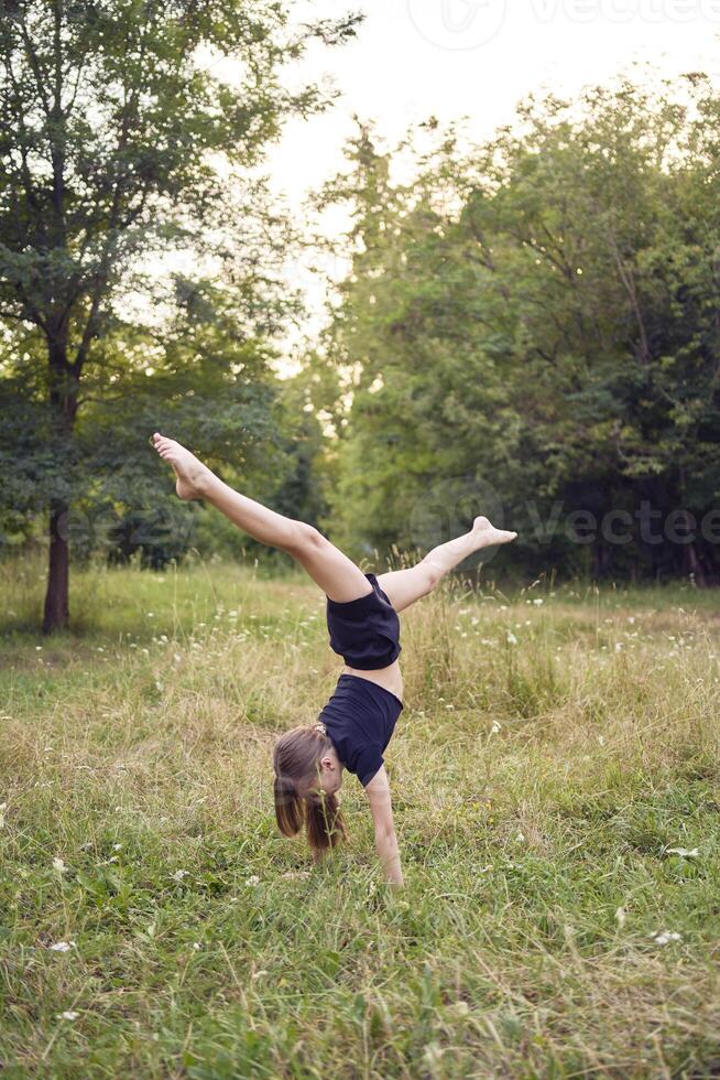 A 10-year-old gymnast practices in the garden photo