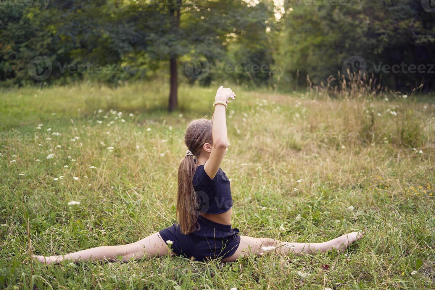 A 10-year-old gymnast practices in the garden photo