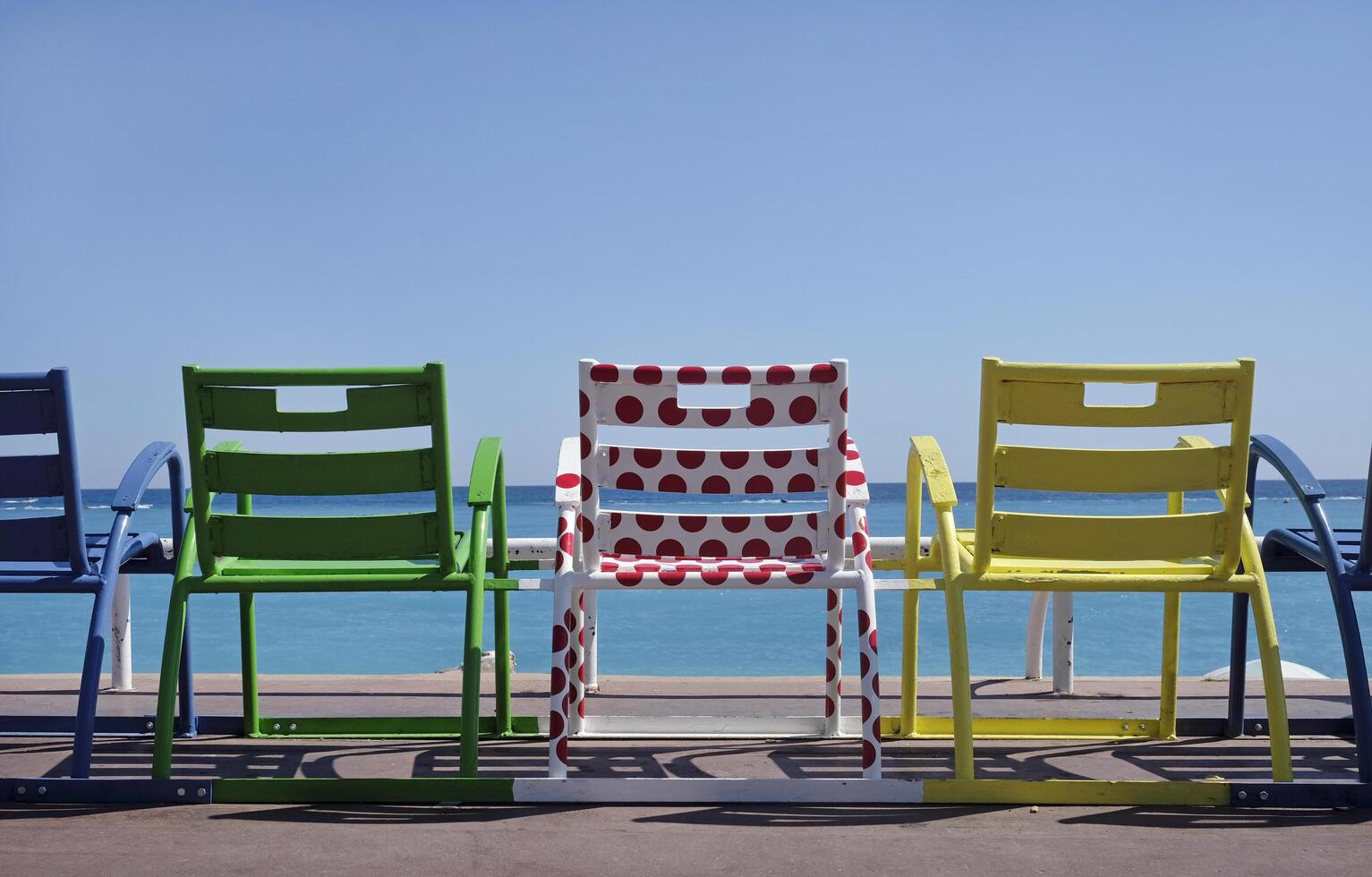 Colorful chairs at the coast of Nice, France, in the colors of the Tour de France jerseys photo