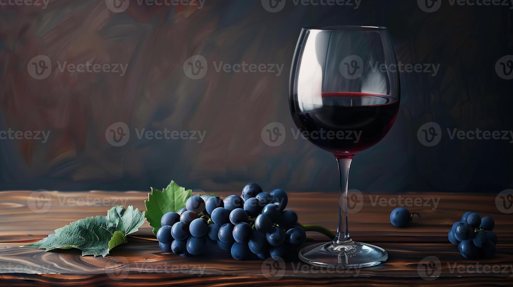 a glass of red wine and a bunch of grapes photo