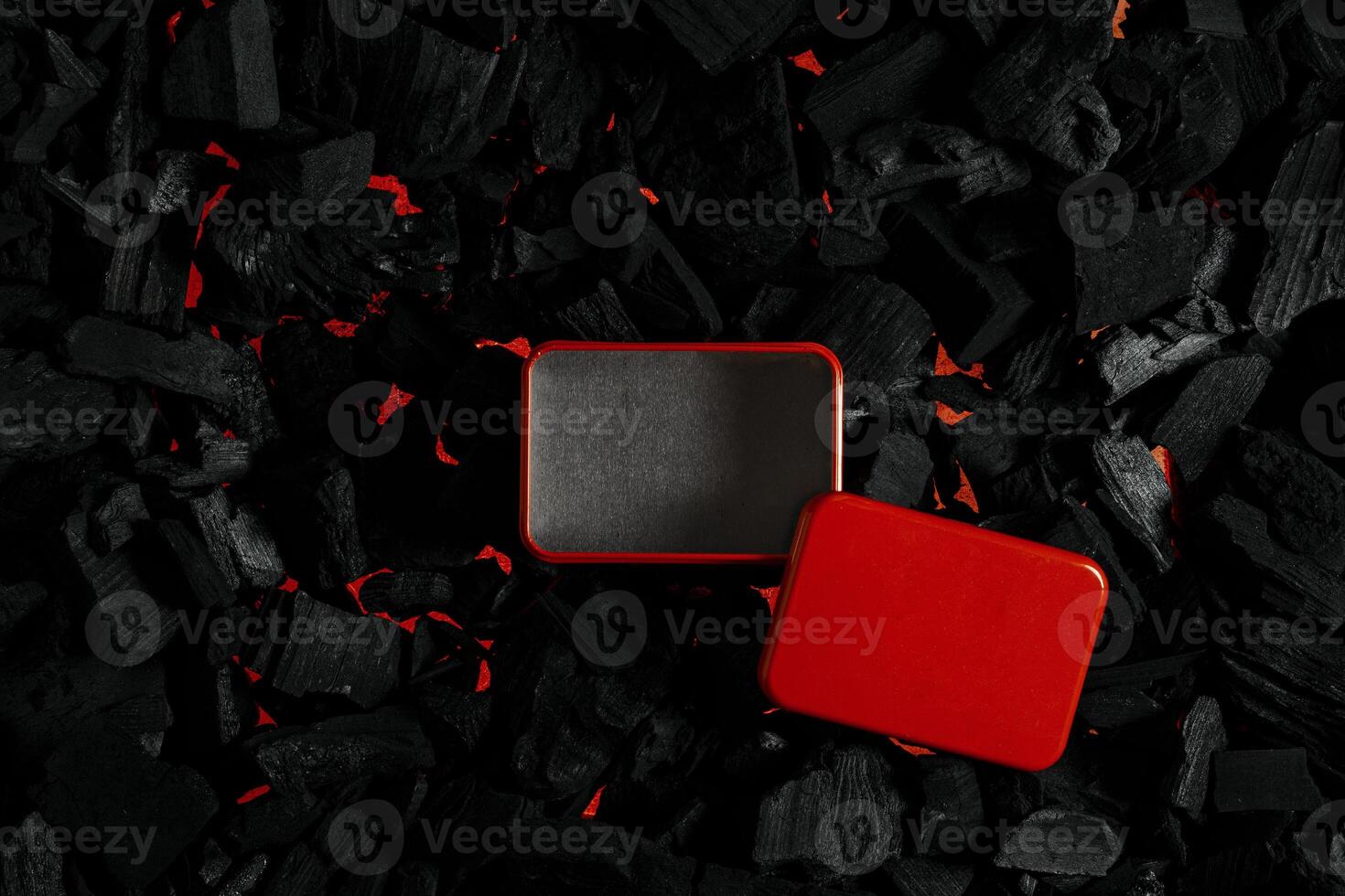 Red metal box on charcoal back. Copy space in a rectangle on a background of hot coals photo