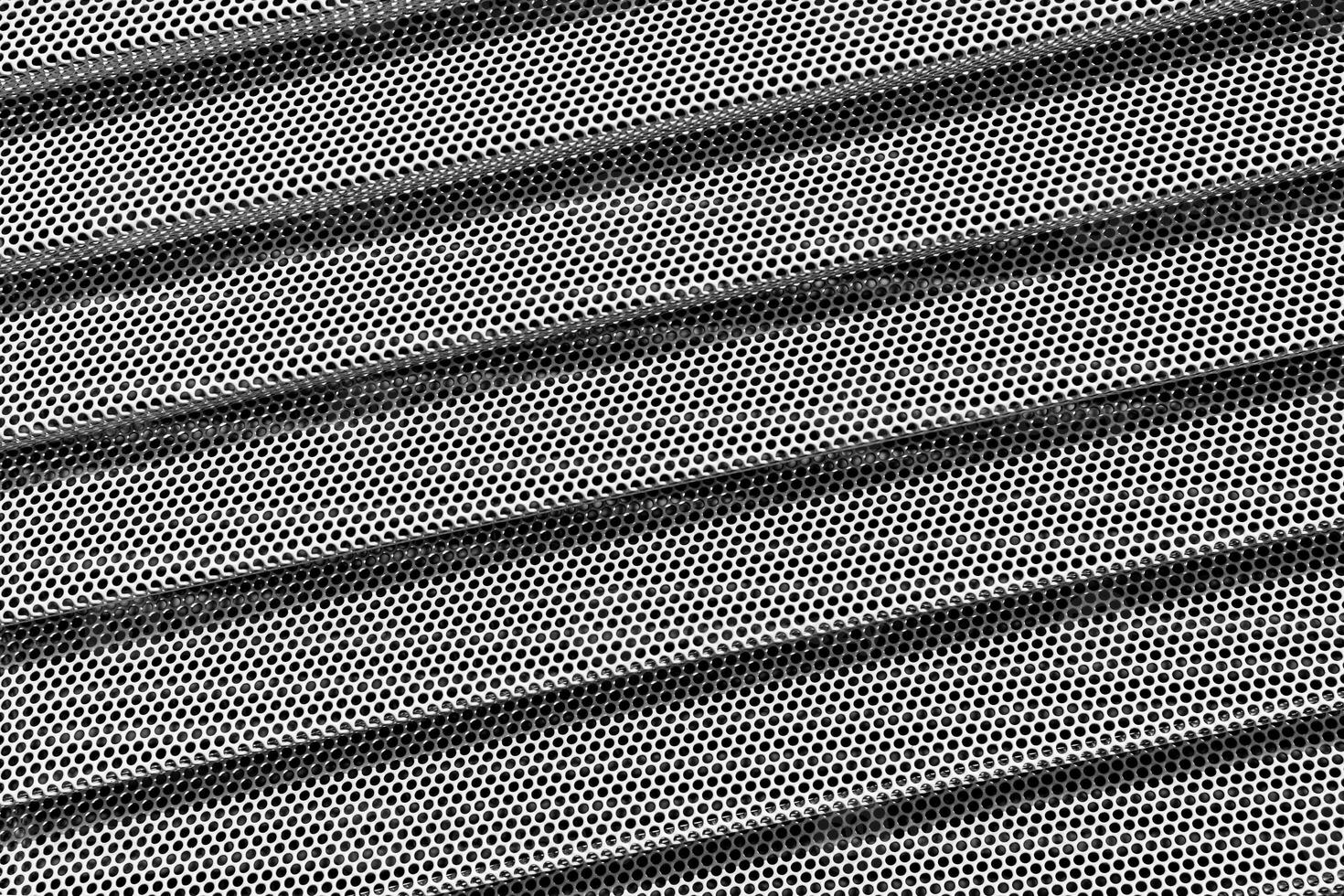 Background of wavy metallic grid with holes. Metal mesh as background. Perforated metal back. photo