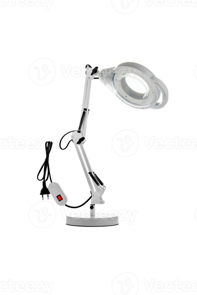 Table lamp with a magnifying glass. Magnifying glass with illumination on a white back photo
