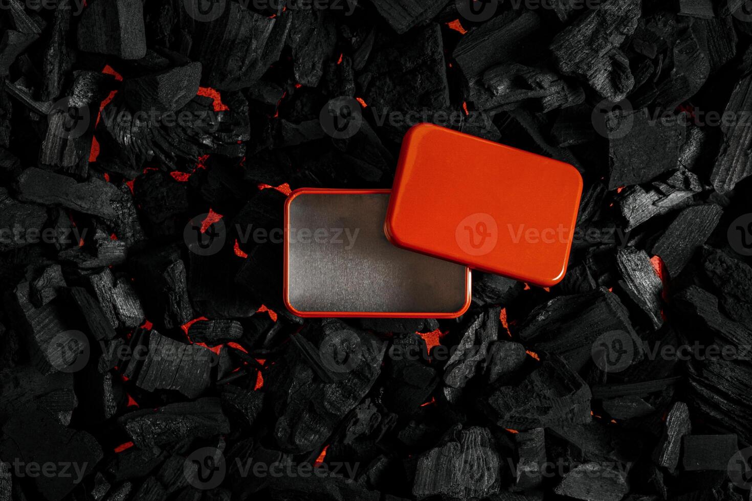 Red metal box on charcoal back. Copy space in a rectangle on a background of hot coals photo